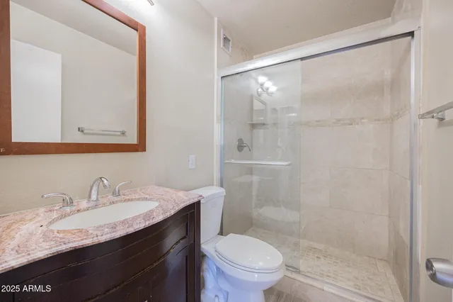 a bathroom with a granite countertop sink toilet and shower
