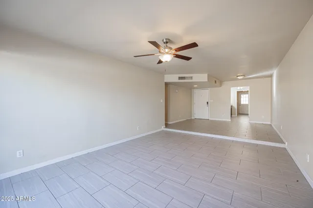 a view of a big room with wooden floor and a ceiling fan