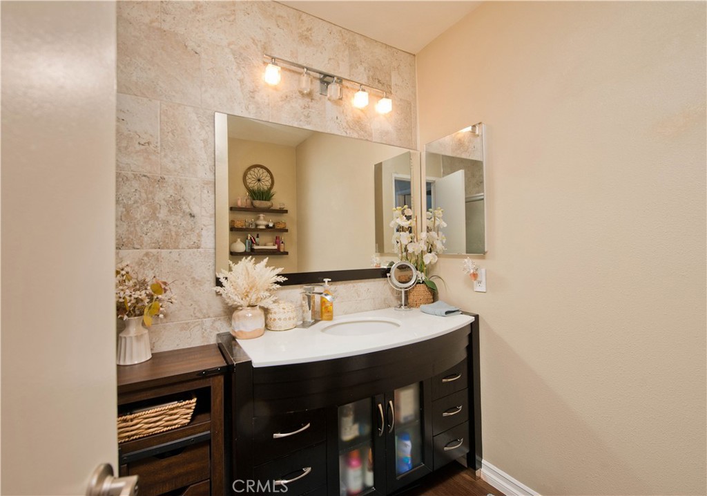 1124 Okapi Lane Ventura, CA 93003 - Photo 11 of 22 a bathroom with a sink a mirror and a shower