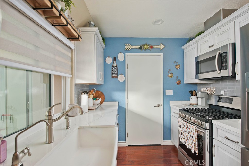 1124 Okapi Lane Ventura, CA 93003 - Photo 7 of 22 a kitchen with stainless steel appliances granite countertop a refrigerator and a stove top oven
