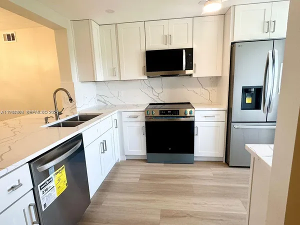 a kitchen with a sink stove and refrigerator