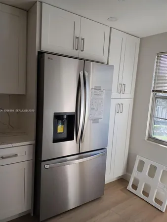 a close view of a refrigerator in kitchen and a window
