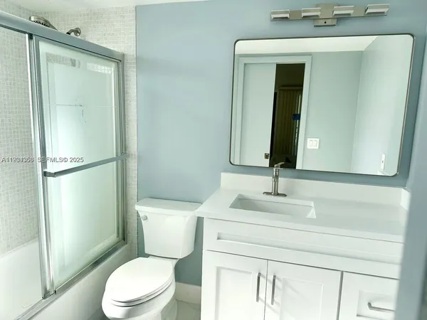 a bathroom with a toilet a sink and a mirror