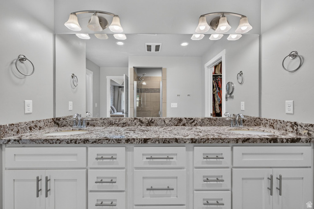 1263 East 1200th South Springville, UT 84663 - Photo 19 of 60 Double vanity featuring white cabinetry, stone-finish countertop, dual undermount sinks, and brushed nickel hardware