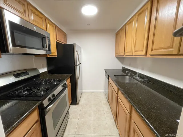 a kitchen with granite countertop stainless steel appliances and wooden cabinets