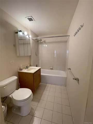 a bathroom with a toilet a sink a mirror and bathtub