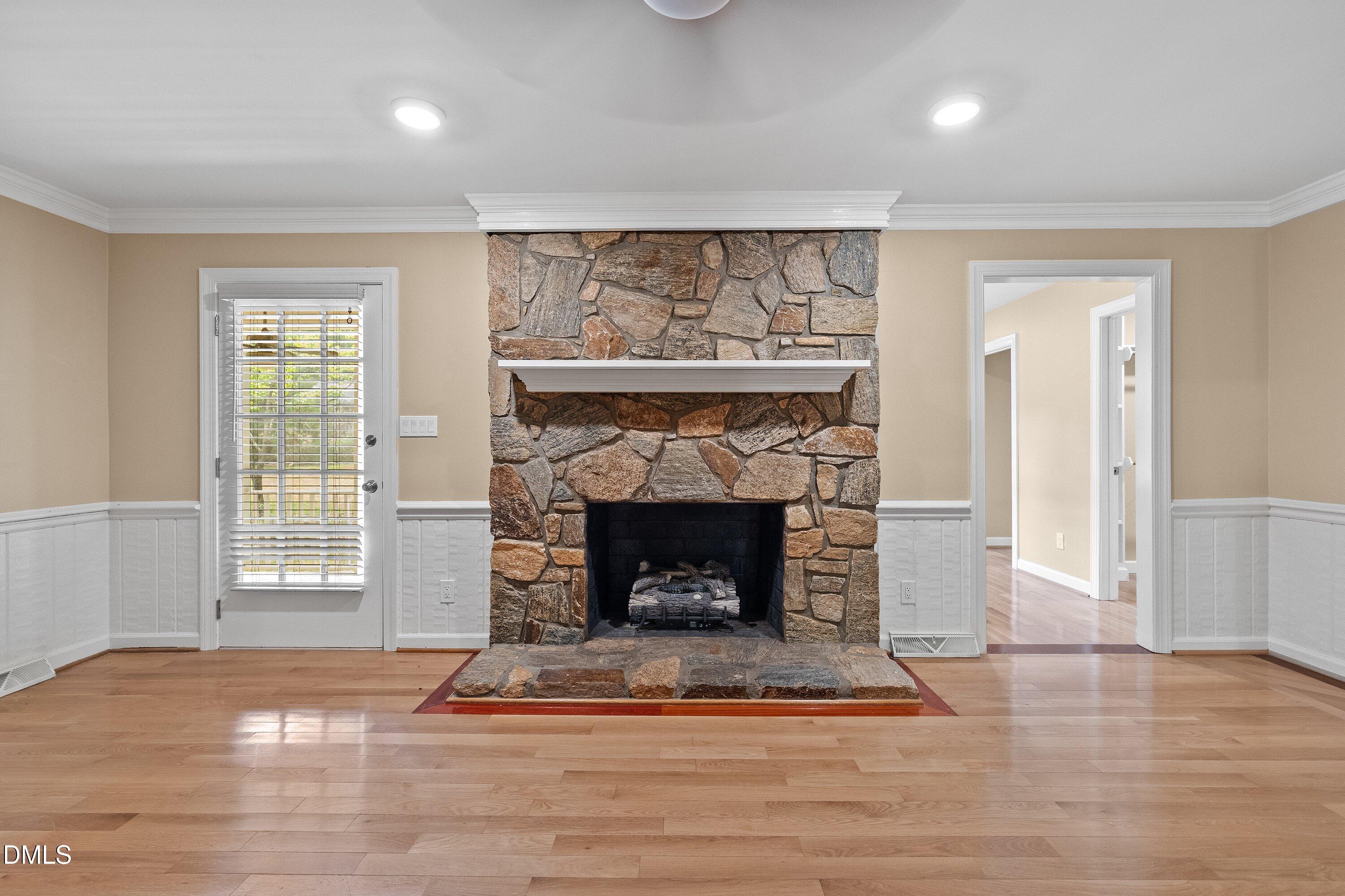 8133 Holly Forest Road Wake Forest, NC 27587 - Photo 8 of 50 a living room with a fireplace and a floor to ceiling window