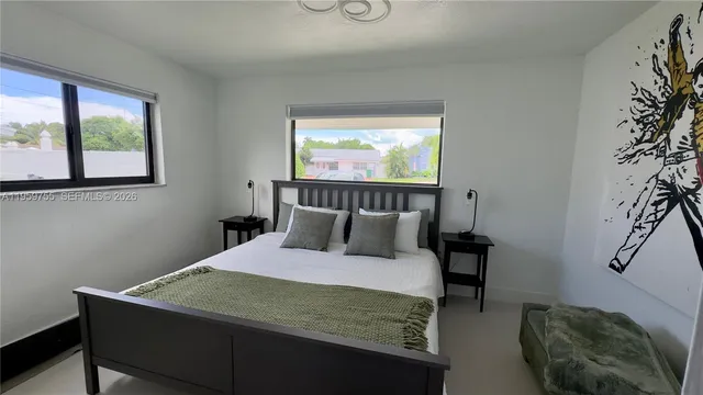 a bedroom with a bed window and a night stand