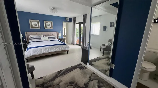 a bedroom with a bed and a view of living room