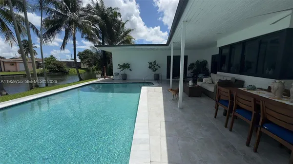 a swimming pool with outdoor seating and yard
