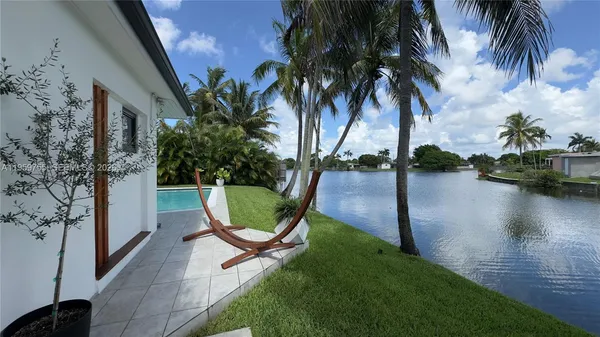 a view of swimming pool with a garden and plants