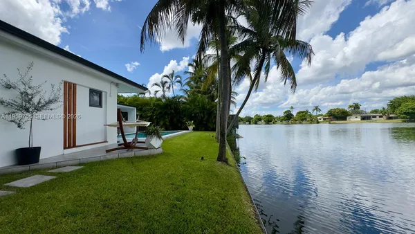 a view of a backyard with a sitting area and a lake view