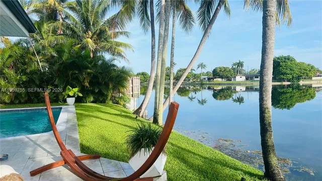 a swimming pool with outdoor seating and plants