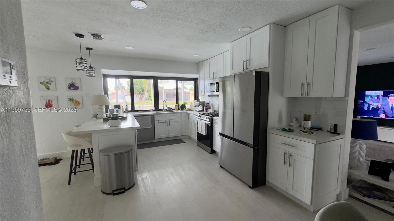 6705 Ficus Drive Miramar, FL 33023 - Photo 6 of 37 a kitchen with a refrigerator a sink dishwasher and a stove with wooden floor