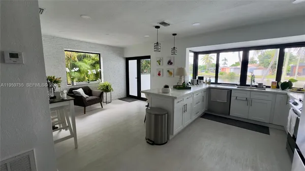 a large white open kitchen with a large window