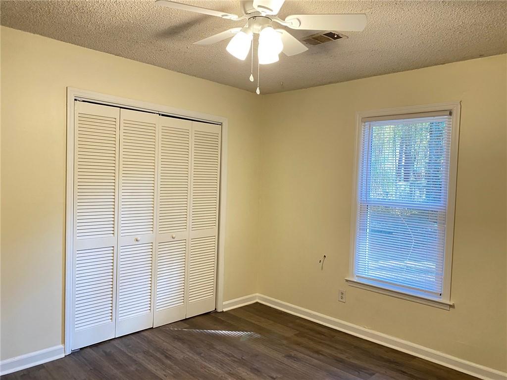 5458 Terrace Garden Way, Unit A Norcross, GA 30071 - Photo 16 of 27 an empty room with wooden floor cabinet and windows