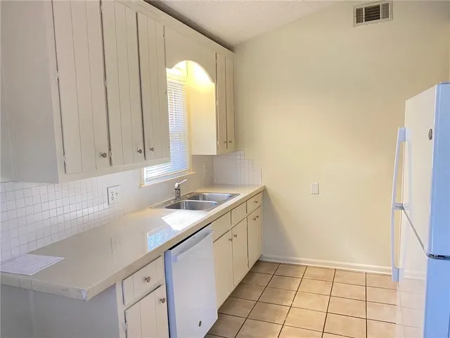 a white refrigerator freezer and a stove sitting inside of a kitchen