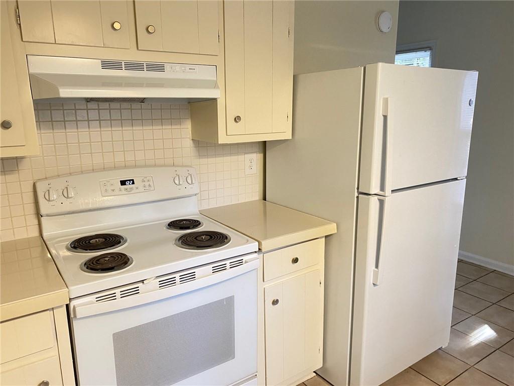 5458 Terrace Garden Way, Unit A Norcross, GA 30071 - Photo 7 of 27 a white refrigerator freezer and a stove sitting inside of a kitchen