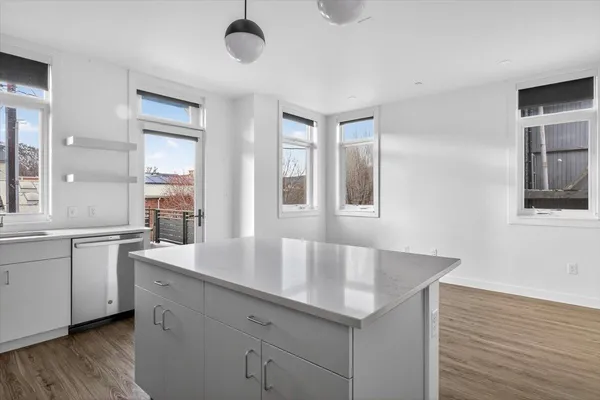 a kitchen with granite countertop a sink and dishwasher with wooden floor