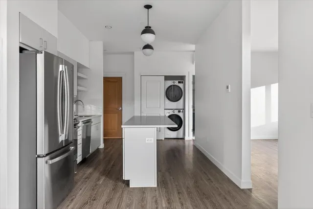 a view of a kitchen with a refrigerator and wooden floor