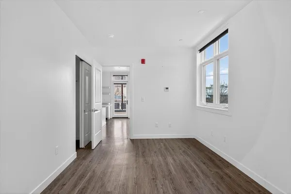 a view of a kitchen with wooden floor and a window