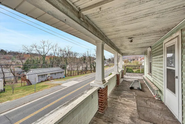 a view of a porch with furniture and floor to ceiling window