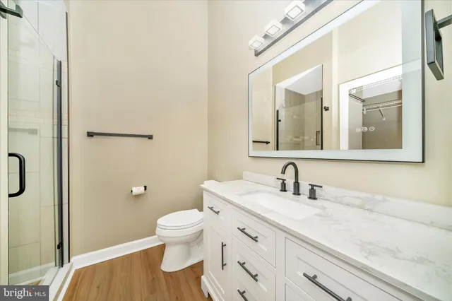 a bathroom with a granite countertop sink a toilet and a mirror