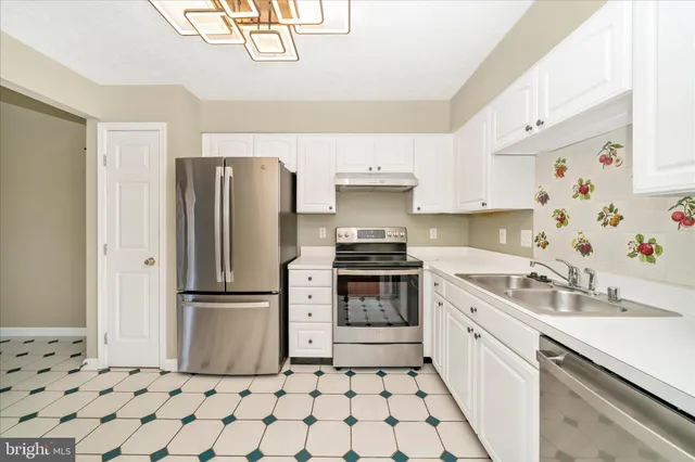 a kitchen with stainless steel appliances a refrigerator sink and cabinets