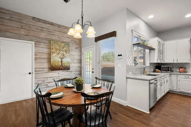 a view of a dining room with furniture a chandelier and wooden floor