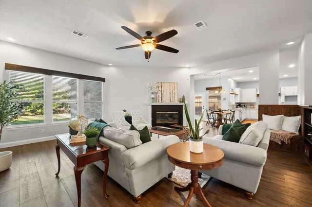 a living room with furniture a fireplace and a large window