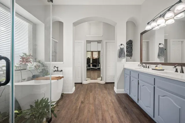 a spacious bathroom with a double vanity sink a mirror and a bathtub