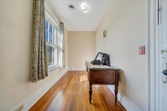 a view of a hallway with wooden floor and staircase