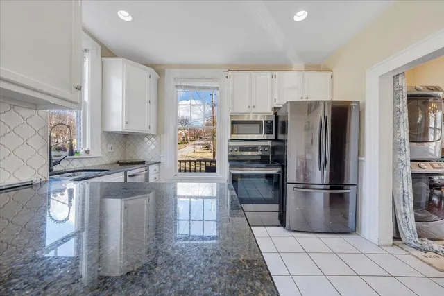 a kitchen with stainless steel appliances granite countertop a refrigerator and a stove