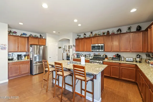 a kitchen with stainless steel appliances granite countertop a refrigerator and a stove top oven