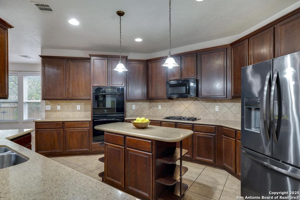 1934 Oak Flat Road San Antonio, TX 78251 - Photo 16 of 33 a kitchen with stainless steel appliances granite countertop a sink stove and refrigerator