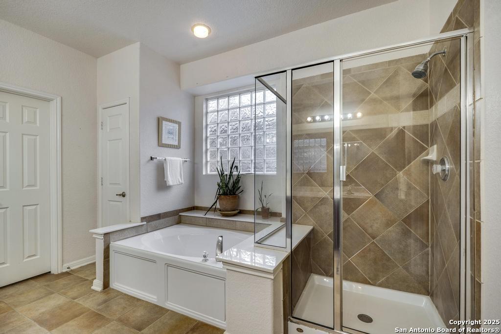 1934 Oak Flat Road San Antonio, TX 78251 - Photo 20 of 33 a bathroom with a granite countertop sink a mirror and a glass door shower
