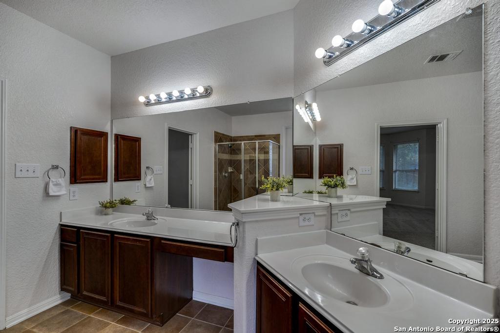 1934 Oak Flat Road San Antonio, TX 78251 - Photo 21 of 33 a bathroom with a sink double vanity and a mirror