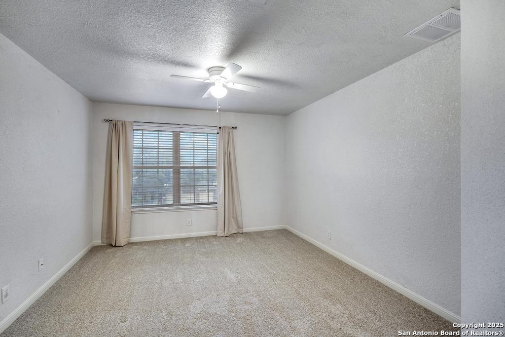 1934 Oak Flat Road San Antonio, TX 78251 - Photo 25 of 33 an empty room with chandelier fan and windows
