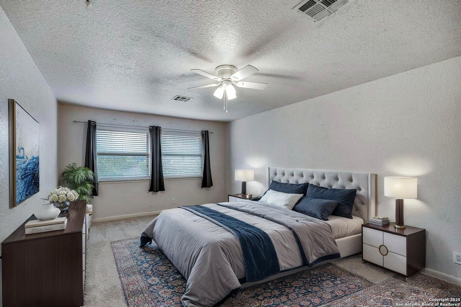 1934 Oak Flat Road San Antonio, TX 78251 - Photo 28 of 33 a bedroom with a large bed and a chandelier