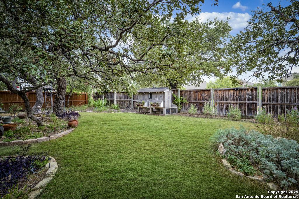 1934 Oak Flat Road San Antonio, TX 78251 - Photo 29 of 33 a view of a backyard with table and chairs and a large tree