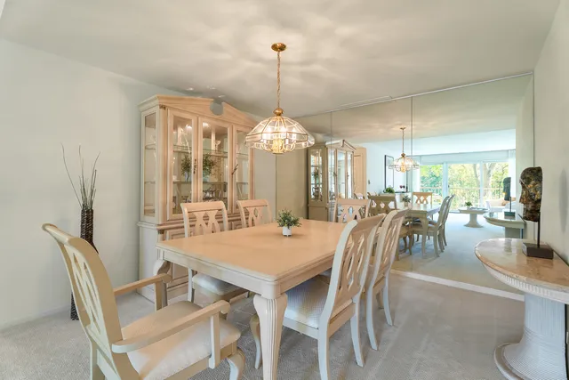 a dining room with furniture a chandelier and wooden floor