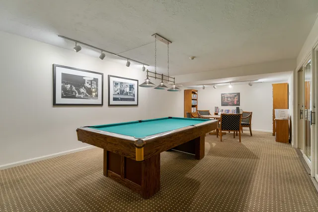 a room with pool table and windows