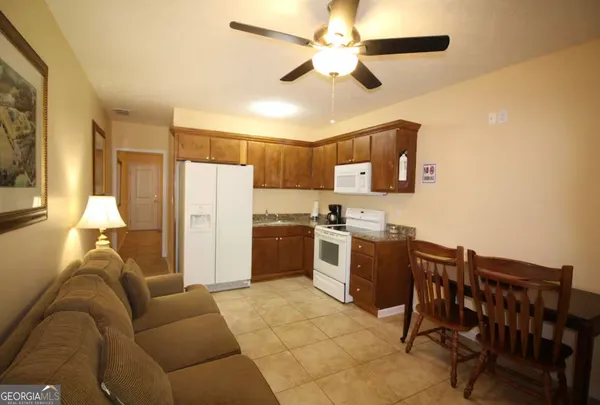 a kitchen with a refrigerator a stove top oven a washer dryer and a dining table