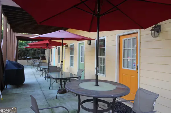 a patio with a table and chairs under an umbrella