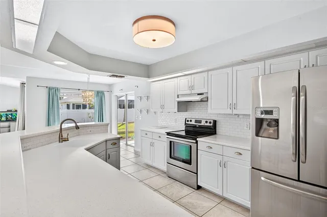 a kitchen with stainless steel appliances granite countertop a refrigerator a stove top oven a sink and dishwasher