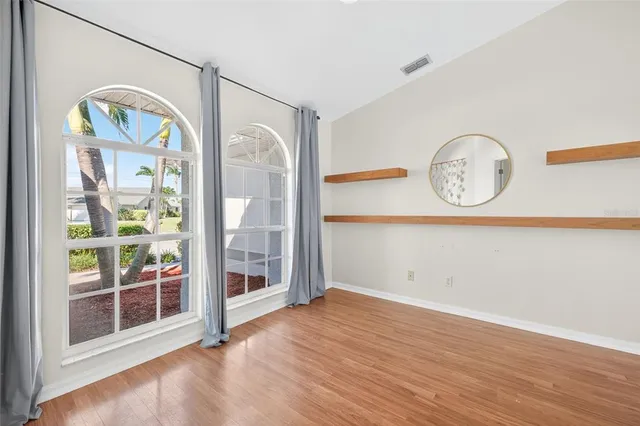 an empty room with wooden floor and glass door