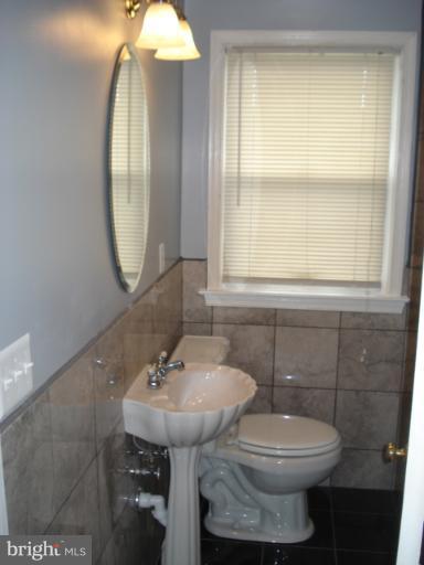 1833 Hanford Road Rosedale, MD 21237 - Photo 3 of 26 a bathroom with a sink a toilet and a mirror