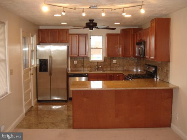1833 Hanford Road Rosedale, MD 21237 - Photo 22 of 26 a view of a kitchen with a refrigerator a sink and a window
