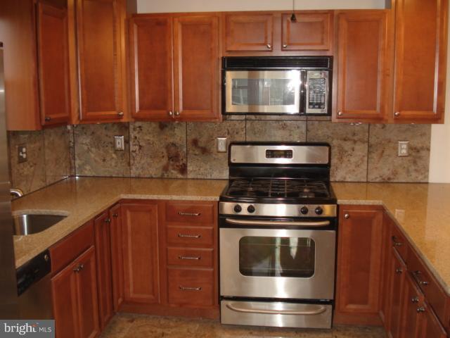 1833 Hanford Road Rosedale, MD 21237 - Photo 10 of 26 a kitchen with granite countertop wood cabinets and stainless steel appliances