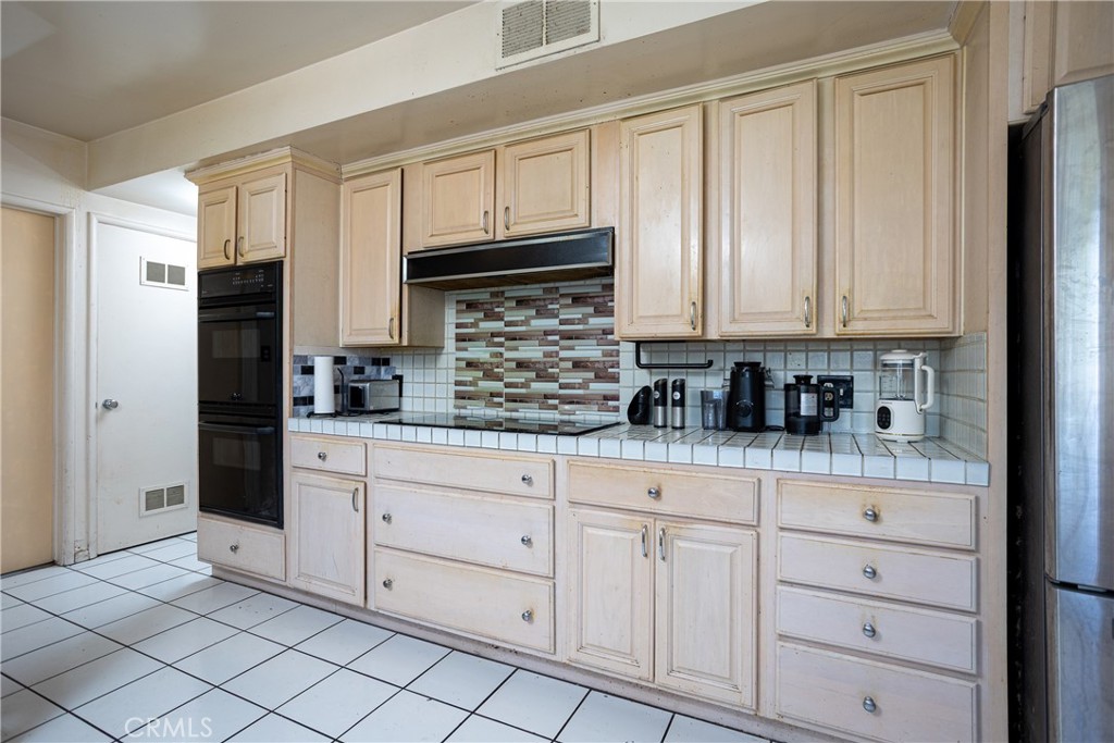 5669 Magnolia Avenue Rialto, CA 92377 - Photo 13 of 35 a kitchen with white cabinets and refrigerator